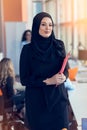 Arabian business woman holding a folder in modern startup office Royalty Free Stock Photo