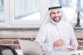Arabian businessman drinking coffee near laptop