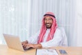 Arabian businessman smile and happy from message his computer notebook in his office Royalty Free Stock Photo