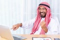 Arabian businessman smile and happy from message his computer notebook in his office Royalty Free Stock Photo