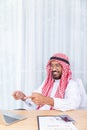 Arabian businessman smile and happy from message his computer notebook in his office Royalty Free Stock Photo