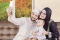 Arabian family taking selfie photo with autumn