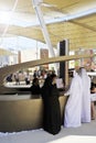 Arabian female receptionist helping smiling customers on the front desk.