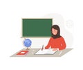 Arabian female teacher in classroom. Pedagogue in hijab sitting at table and checking homework. School and college Royalty Free Stock Photo