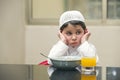 Arabian kid having breakfast of cornflakes and orange juice