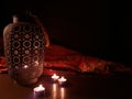 Arabian lantern near a red oriental fabric on a brown wooden background.Eid lamp or lantern for Ramadan and other Islamic Muslim