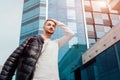 Arabian man holding his coat and walking in city center. Young man puts coat on shoulder. Stylish handsome hipster Royalty Free Stock Photo