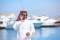 Arabian man talking on the cell phone at the yacht harbor Royalty Free Stock Photo