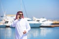 Arabian man talking on the cell phone at the yacht harbor Royalty Free Stock Photo