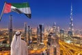 Arabian man watching night cityscape of Dubai with modern futuristic architecture in United Arab Emirates Royalty Free Stock Photo