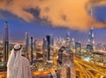 Arabian man watching night cityscape of Dubai with modern futuristic architecture in United Arab Emirates Royalty Free Stock Photo