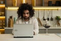 Arabian man works online on laptop enjoying glass of wine Royalty Free Stock Photo