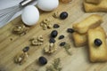 Arabian Mediterranean food ingredient egg, teac, rusk biscuit, black olives, walnut, zaatar, thyme, raisins on wooden platter