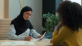 Arabian muslim islamic woman in hijab female investor employer signing contract document conclude business deal