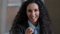 Arabian smiling curly woman employee business lady pointing index finger at camera emotionally speaking explaining Royalty Free Stock Photo