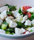 Close view Feta Salad in bowl on wooden serving plate