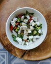 Top View Feta Salad in bowl on wooden serving plate