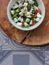 Top View Feta Salad in bowl on wooden serving plate