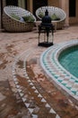 Arabian style tiled floor in a green hammer with brown bricks floor and relaxing sofa and black lamp