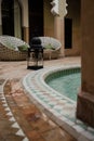 Arabian style tiled floor in a green hammer with brown bricks floor and relaxing sofa and black lamp in a Riyadh in Marrakesh, Mor