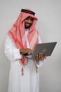 an arabian in a turban smiling while using a laptop computer