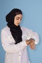 Arabian woman in the hijab checking the time. Woman feeling unhappy being late to a meeting. Portrait of amazed middle-eastern Royalty Free Stock Photo