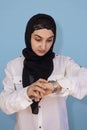 Arabian woman in the hijab checking the time. Woman feeling unhappy being late to a meeting. Portrait of amazed middle-eastern Royalty Free Stock Photo