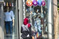 Cairo, Egypt - September 16, 2018: Arabian Woman with red hijab walking in front of a westernized shop, in Cairo, Egypt