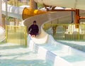 Arabian woman sliding down on water-slide in waterpark. Royalty Free Stock Photo