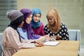 Arabian young women watching on cellphone musical video clip standing together. Royalty Free Stock Photo