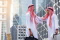 Two Arabian meet and talking together in downtown with city background