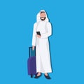 Arabic businessman using smartphone holding valise wearing traditional clothes travel concept male cartoon character
