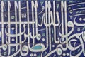 Arabic calligraphy on blue ceramic tiles.