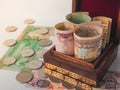 Arabic coins of dirhams. Curled banknotes in his hands.