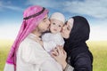 Arabic family kiss their child at the park Royalty Free Stock Photo
