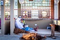 Arabic fisherman, repairing home-made fishing net and wooden yacht, wearing face mask and sits on the floor of traditional boam Royalty Free Stock Photo