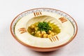 Arabic food Hummus with parsley in a traditional bowl.