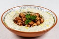 Arabic food Hummus with parsley in a traditional bowl.