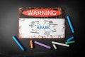 ARABIC, Language learning Concept. Metal warning sign and colored pieces of chalk on a dark chalkboard background Royalty Free Stock Photo