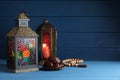 Arabic lanterns, dates and misbaha on wooden table. Space for text