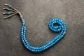 Arabic letter wav made with blue rosary on gray rustic background