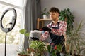 Arabic male gardener influencer films video for blog gives recommendations how to transplant potted flower