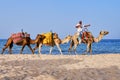 Arabic man on a caravan of camels rides along the sea. Arabian rider in the beach middle East - Tunisia, Sousse, Africa 06 13 2019