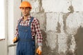 Arabic man master plasters the walls, portrait of builder in hard hat making repairs in the apartment, repairing and