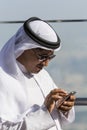 Arabic man tapping on his iphone