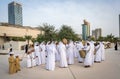 Arabic men standing in traditional cloth around modern buildings - Middle Eastern Culture - Emirati Men performing Al Ayala