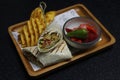 arabic middle eastern falafel wrap with potato chips and pickle