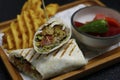 arabic middle eastern falafel wrap with potato chips and pickle in close up