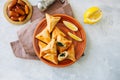 Arabic and middle eastern food concept. Fatayer sabanekh - traditional arabic spinach triangle hand pies dates and tea on a white Royalty Free Stock Photo