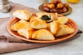 Arabic and middle eastern food concept. Fatayer sabanekh - traditional arabic spinach triangle hand pies dates and tea on a white Royalty Free Stock Photo